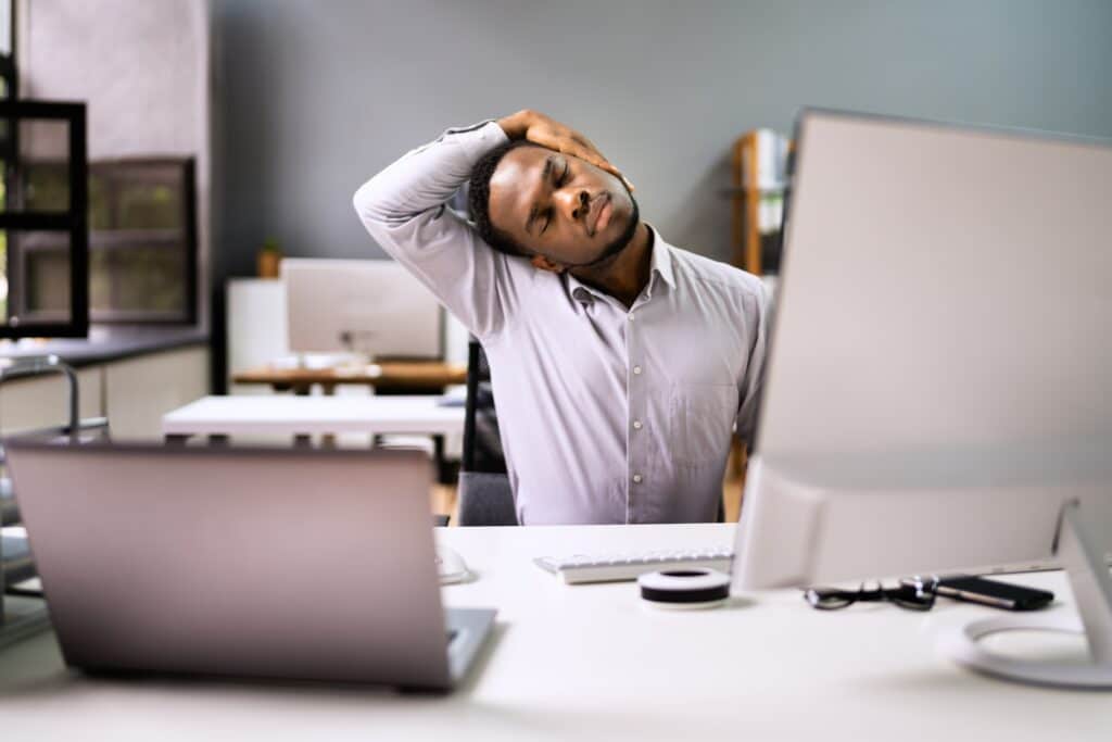 Employee,Stretching,At,Office,Desk,At,Work