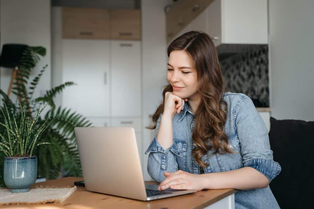 Happy,Smiling,Woman,Sitting,On,Couch,,Couch,And,Using,Laptop
